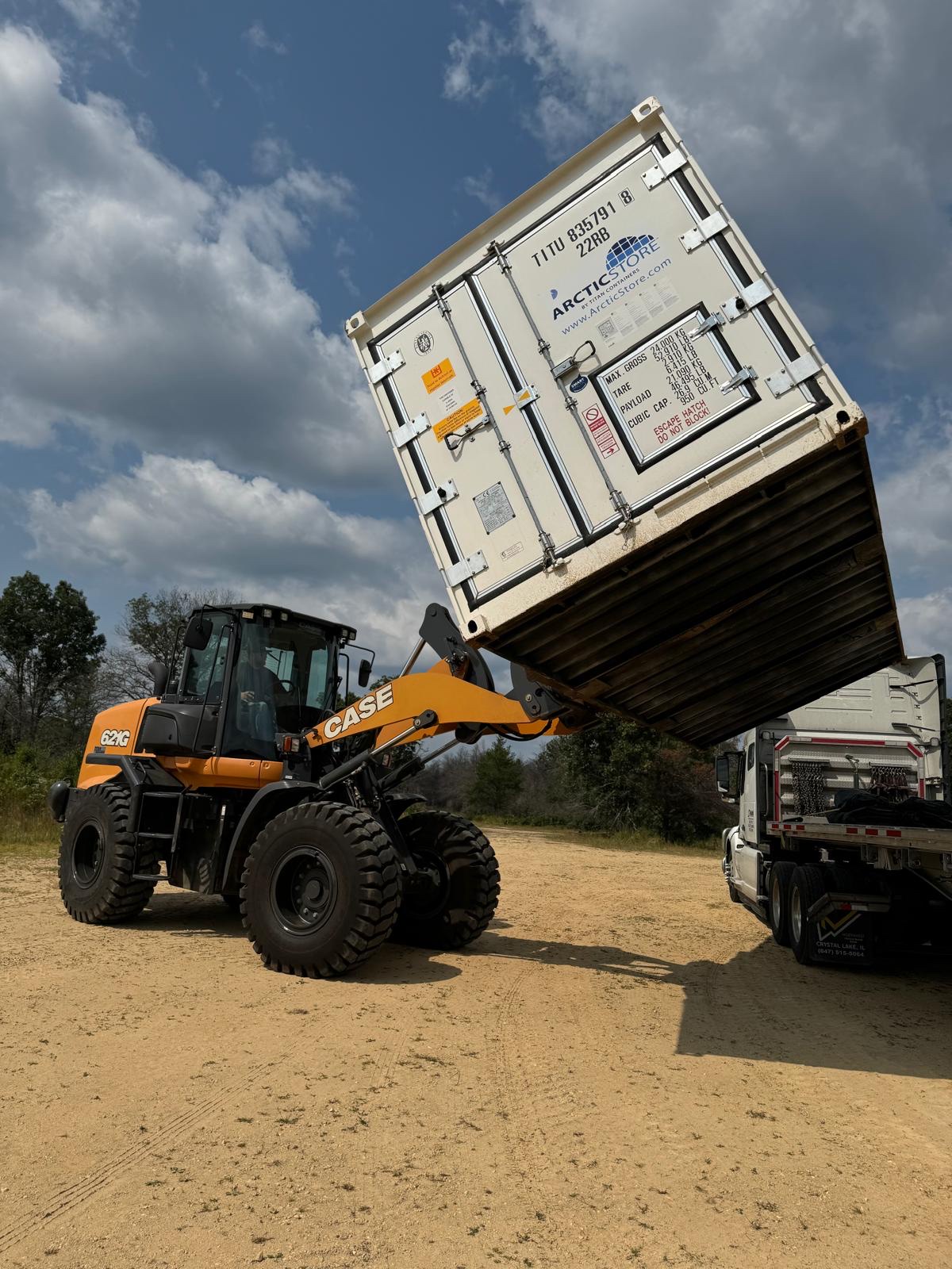 Wheel loader placing a refrigerated container at a field site